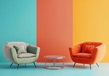 Duas poltronas estofadas arredondadas, uma verde-clara e outra laranja, em frente a uma parede dividida em três faixas verticais (azul, coral e laranja).